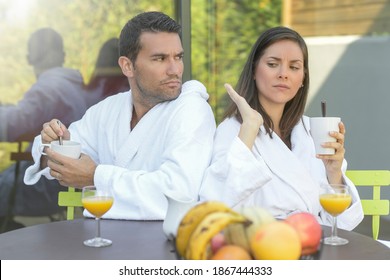 Happy young couple in bathrobes having breakfast outdoors - Powered by Shutterstock