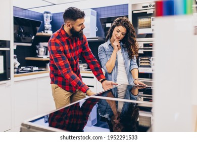 Happy Young Couple Buying Electric Cooktop In Store.