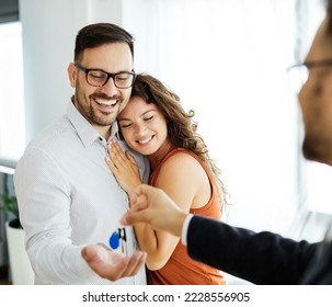 Happy young couple buying a new house receiving the keys  - Powered by Shutterstock