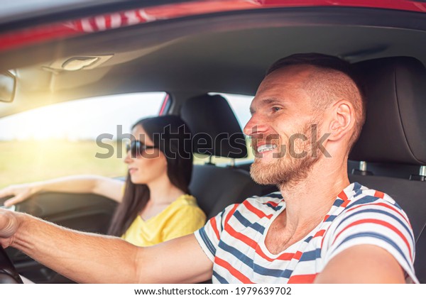 Happy young couple in the car. The guy and the girl\
travel by car.