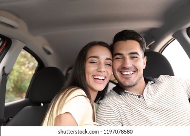 Happy young couple in car on road trip - Powered by Shutterstock