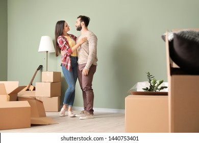 Happy Young Couple With Cardboard Boxes In Their New House