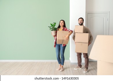 Happy young couple with cardboard boxes in their new house