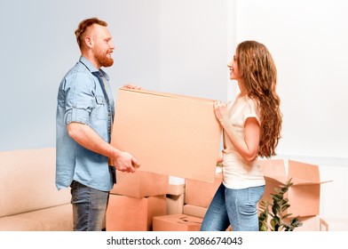 Happy Young Couple Carry Cardboard Box In Hands While Moving To New Home