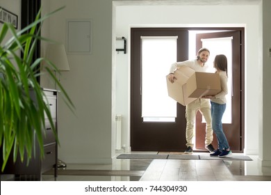 Happy Young Couple Carrying Cardboard Boxes Opening Door Entering Inside Modern Own House, Excited Married Family Property Owners Moving In Into New Home, Buying Real Estate, Mortgage Loan 