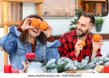 Happy young couple celebrating Christmas outdoors