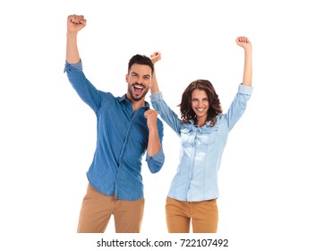 Happy Young Couple Celebrating Success With Hands Up In The Air On White Background