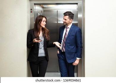 Happy Young Couple Coming Out From An Elevator