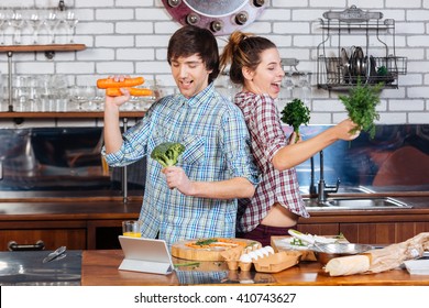 Happy Young Couple Cooking And Dancing On The Kitchen