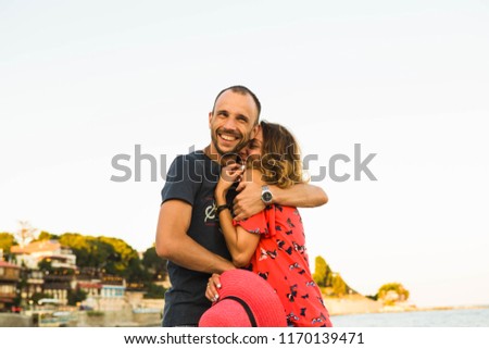 Happy young couple cuddling and smiling on the beautiful sea beach.