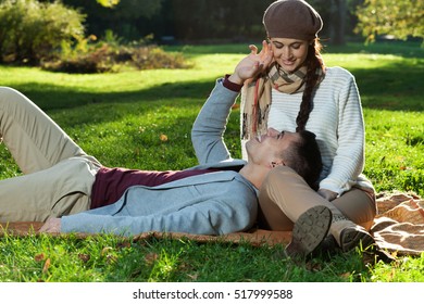 Happy Young Couple Cuddling While Laying On The Grass