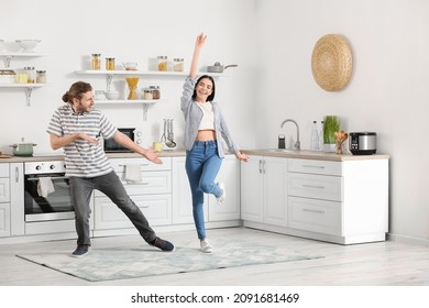 Happy Young Couple Dancing In Kitchen