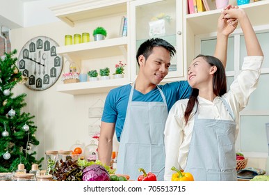 Happy Young Couple Dancing In The Kitchen At Home