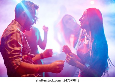 Happy Young Couple Dancing In Night Club