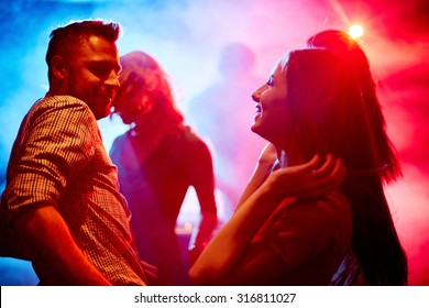 Happy Young Couple Dancing At Party In Disco Club