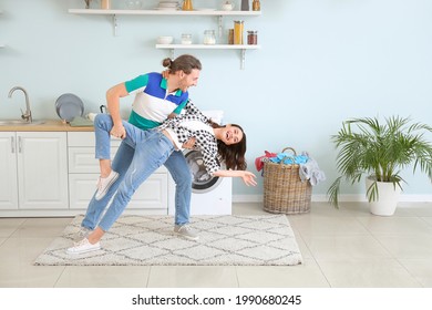 Happy Young Couple Dancing While Doing Laundry At Home