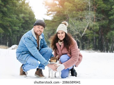 Happy Young Couple With Dog In Forest On Winter Day