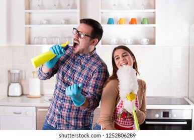 Happy Young Couple Doing Chores, Singing And Having Fun