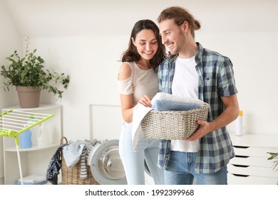 Happy Young Couple Doing Laundry At Home