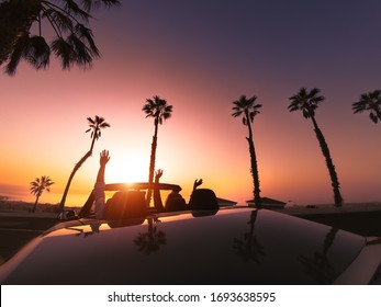 Happy young couple doing road trip in tropical city - Travel people having fun driving in trendy convertible car discovering new places - Relationship and youth vacation lifestyle concept