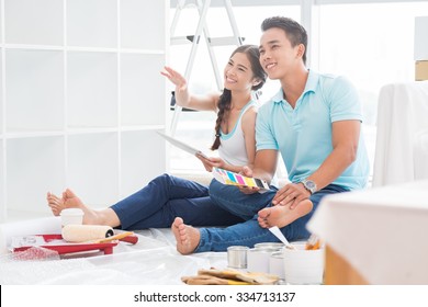 Happy Young Couple Dreaming How They Will Furnish Apartment