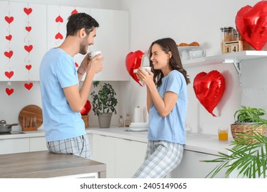 Happy young couple drinking coffee in kitchen on Valentine's Day - Powered by Shutterstock