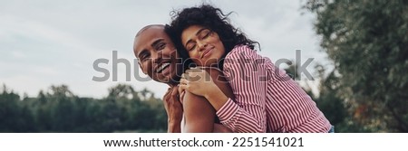 Happy young couple embracing and smiling while sitting outdoors
