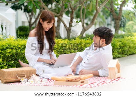 Happy young couple go picnic and dating at the park in summer.