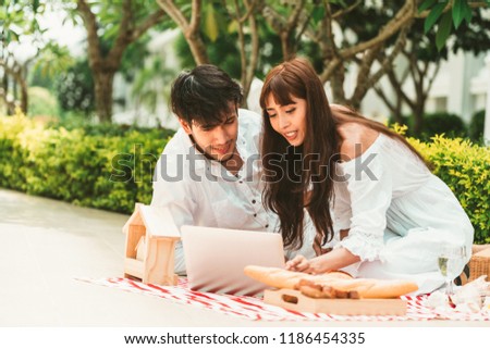 Happy young couple go picnic and dating at the park in summer.