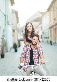 Happy Young Couple Going For A Bike Ride In The City On A Sunny Summer Day