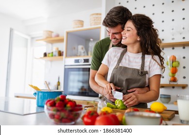 Happy Young Couple Have Fun In Modern Kitchen While Preparing Fresh Food