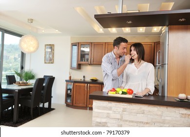 happy young couple have fun in modern wooden  kitchen indoor while preparing fresh food - Powered by Shutterstock