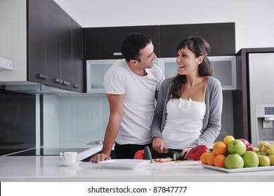 happy young couple have fun in  modern kitchen indoor  while preparing fresh fruits and vegetables food salad - Powered by Shutterstock