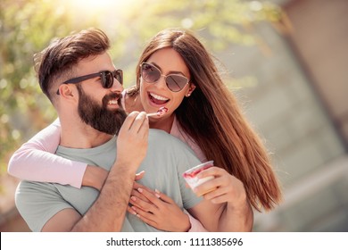 Happy young couple having fun outdoors and smiling,eating ice cream. - Powered by Shutterstock
