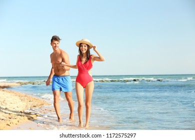 Happy Young Couple Having Fun At Beach On Sunny Day