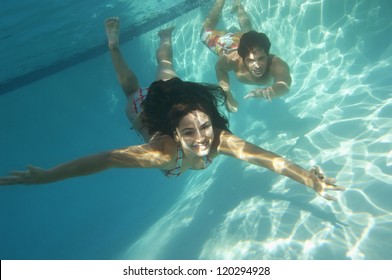 A happy young couple having fun in swimming pool - Powered by Shutterstock