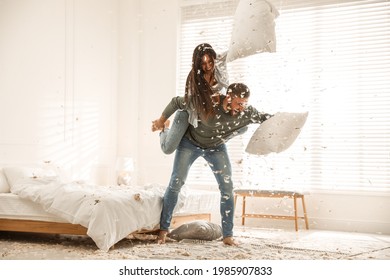 Happy young couple having fun pillow fight in bedroom - Powered by Shutterstock