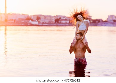 Happy Young Couple Having Fun, Man And Woman In The Sea On The Beach. Vintage Retro Style With Soft Focus And Sun Flare