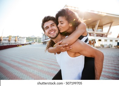 Happy young couple having fun and kissing outdoors - Powered by Shutterstock