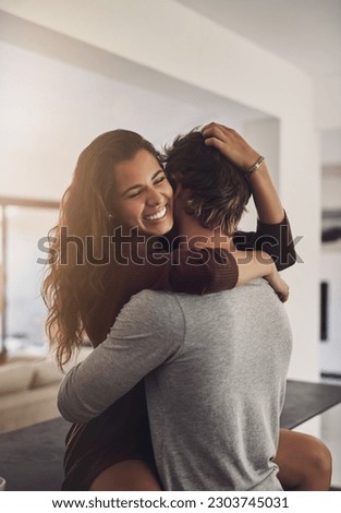 Happy young couple hugging in home for love, romance and caring bond together with excited partner. Woman, man and hug of lovers in relationship, dating and smile for happiness, care and loyalty