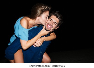 Happy Young Couple Kissing And Having Fun On The Beach At Night