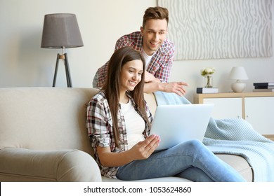 Happy young couple with laptop, indoors - Shutterstock ID 1053624860