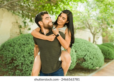 Happy young couple laughing and embracing on a sunny day outside, showcasing the affection and bond of their romantic relationship - Powered by Shutterstock