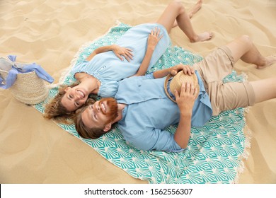 happy young couple laying on the beach