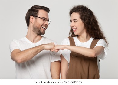 Happy young couple looking greeting each other giving fist bump hands gesture celebrating successfully passed exam or common success, like-minded people showing respect, solidarity, friendship concept
