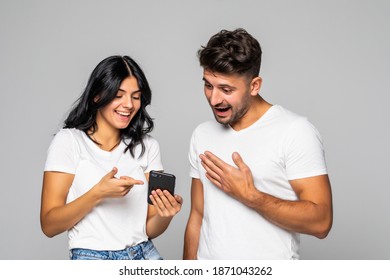 Happy Young Couple Looking At Mobile Phone On White Background