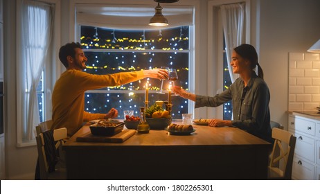 Happy Young Couple in Love Have Romantic Dinner, Toasting Each other with Glasses of Wine, Eating Tasty Meal in the Kitchen, Celebrating, Talking. Beautiful Lovely Husband and Wife Have Romantic Time - Shutterstock ID 1802265301