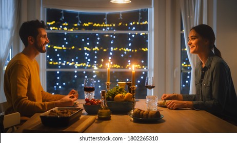 Happy Young Couple In Love Have Romantic Dinner, Eating Tasty Meal In The Kitchen, Celebrating, Talking. Beautiful Lovely Husband And Wife Have Romantic Time