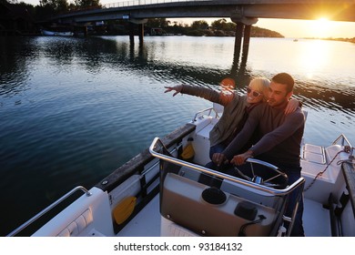 jeune couple heureux amoureux au coucher du soleil   à bord d'un bateau, tout en représentant le mode de vie de fashin urbain et rural