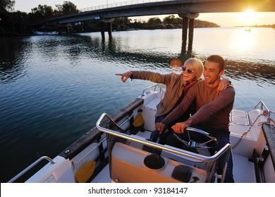 jeune couple heureux amoureux au coucher du soleil   à bord d'un bateau, tout en représentant le mode de vie de fashin urbain et rural